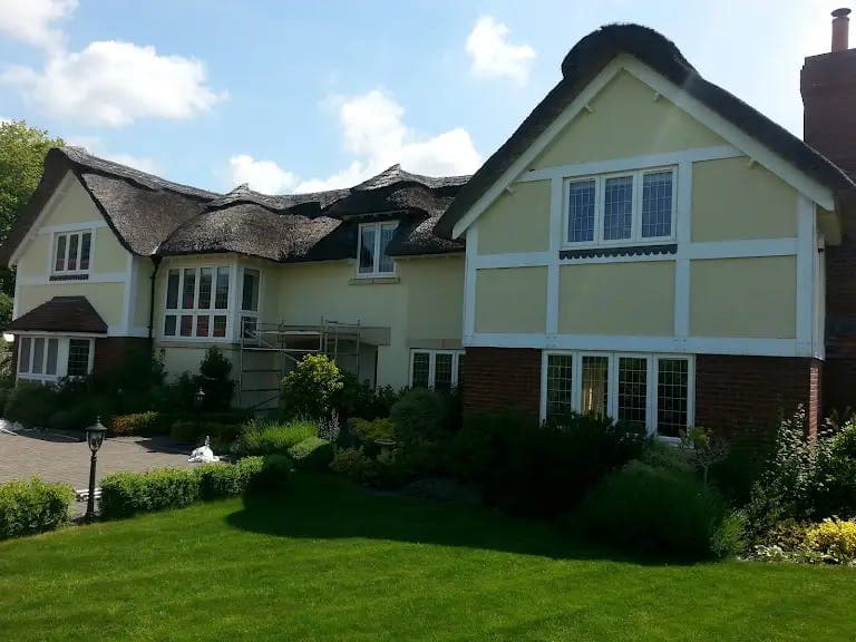 Repainted thatched house exterior in cream