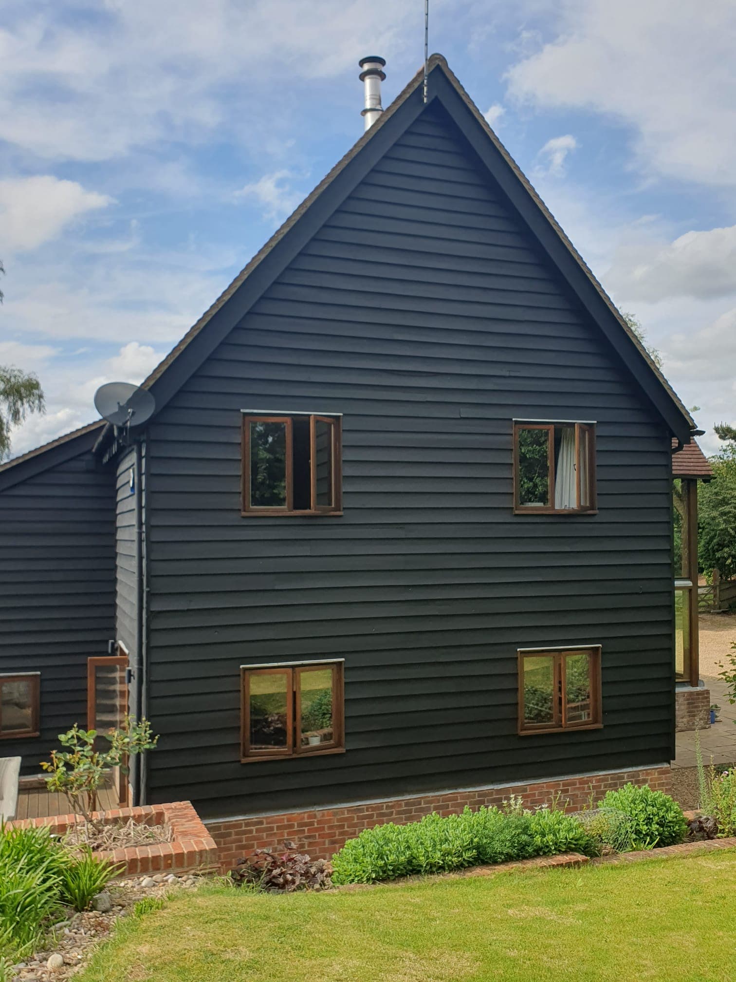 Gable end of a black timber-clad barn conversion