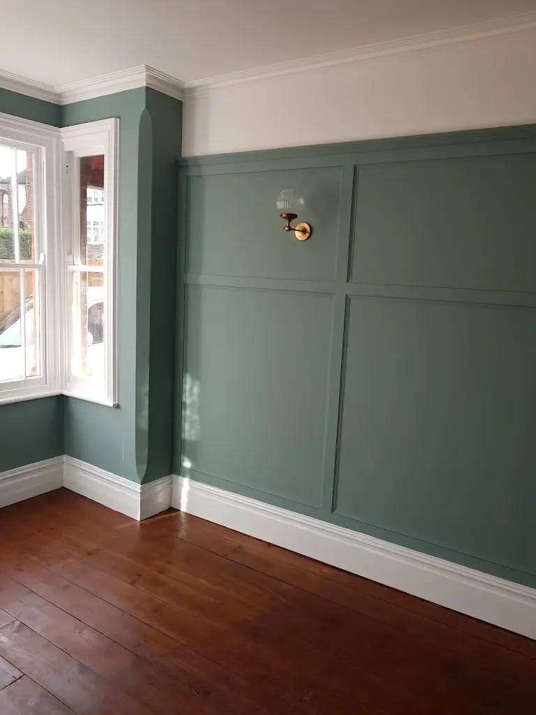 Deep green painted wall panelling in a period room