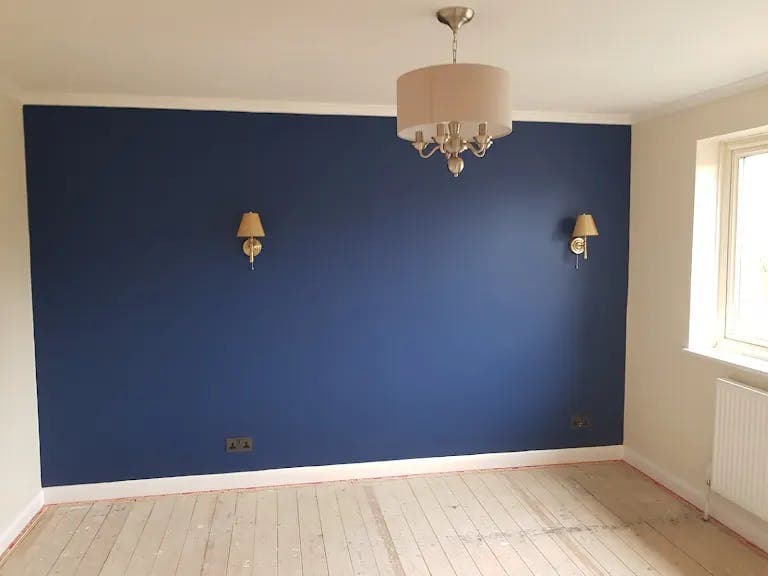 Navy feature wall with wall lights and chandelier