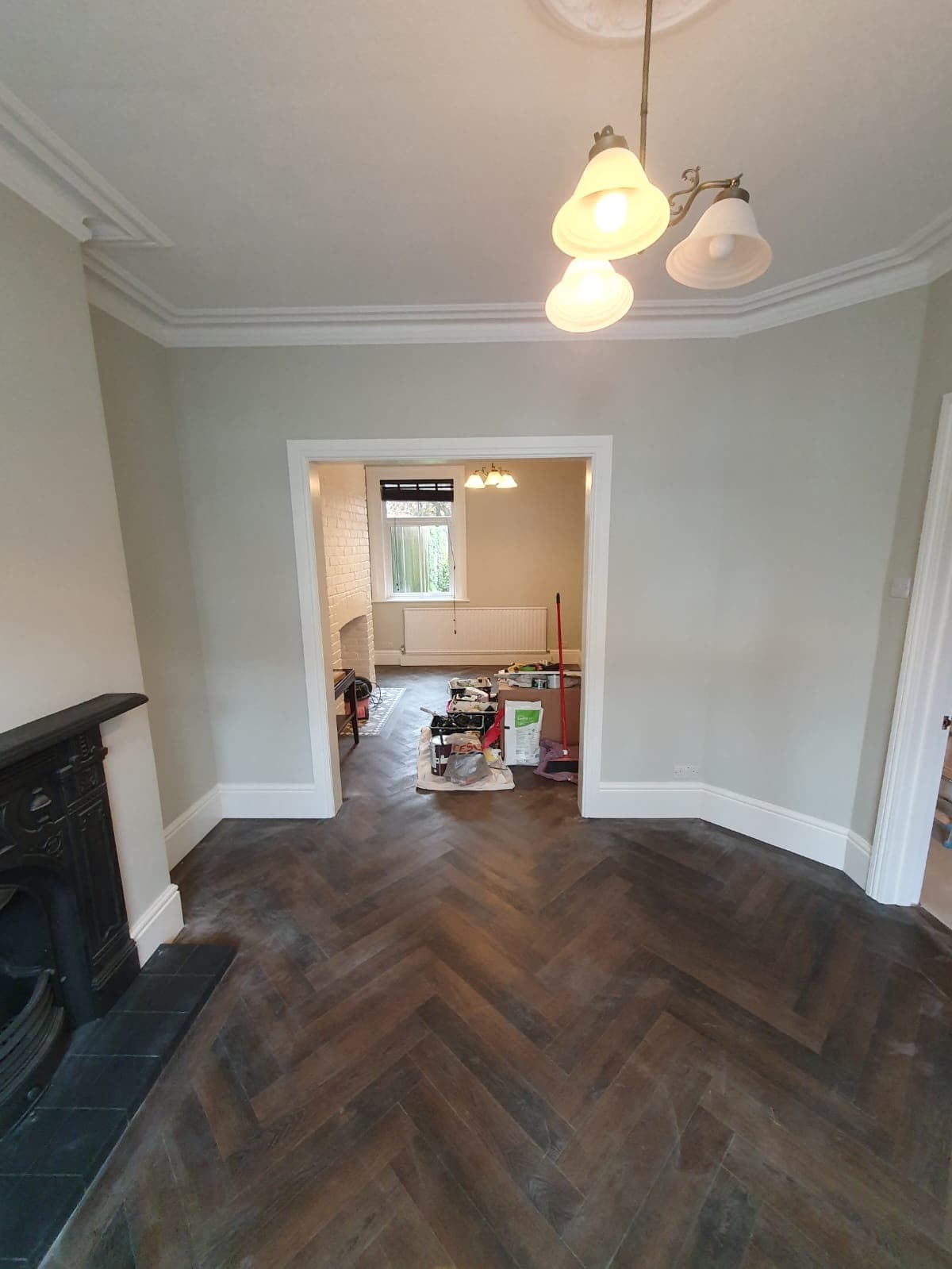 Sage room with herringbone floor and restored fireplace