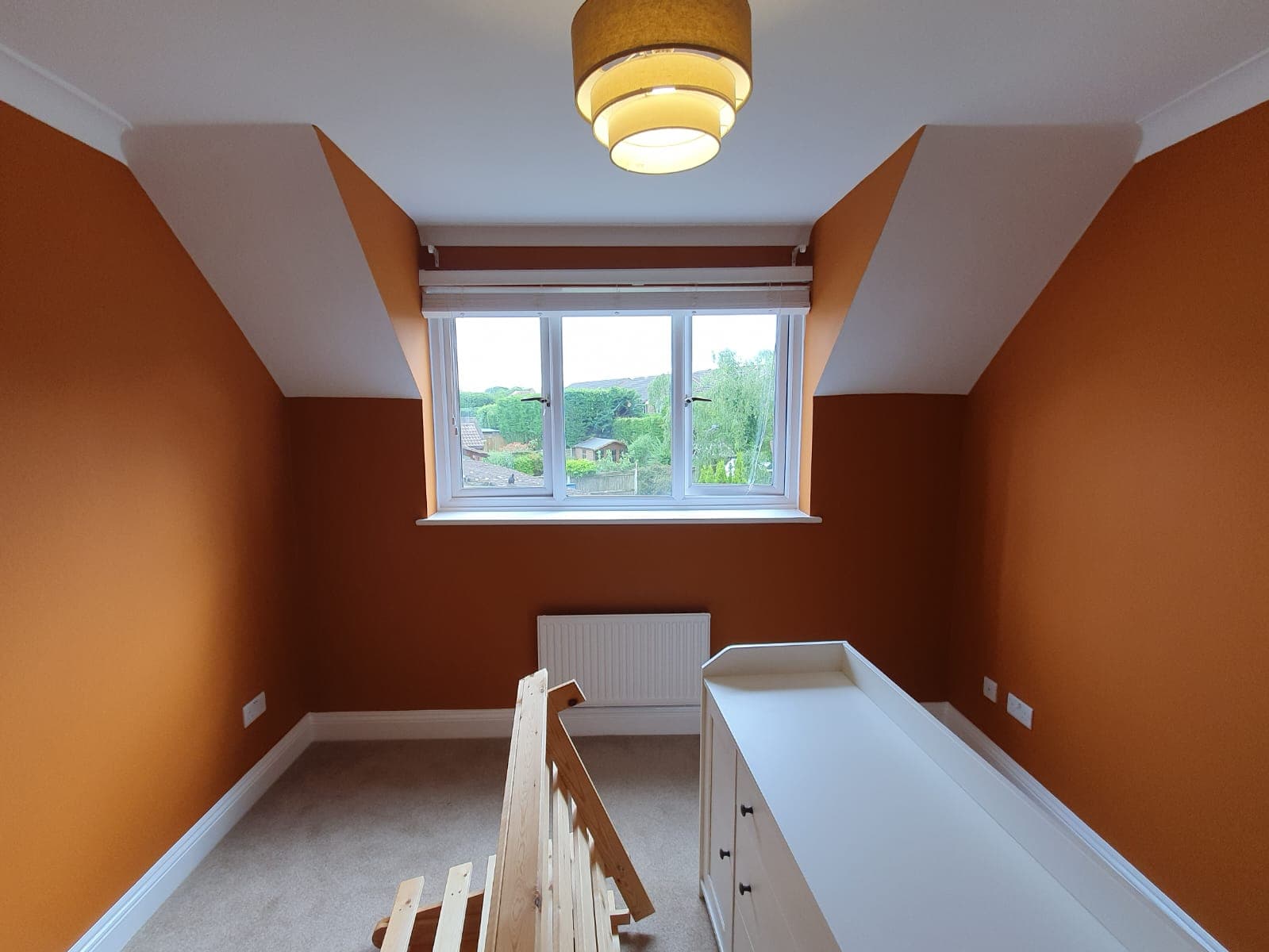 Loft bedroom with terracotta walls and white ceiling and trim